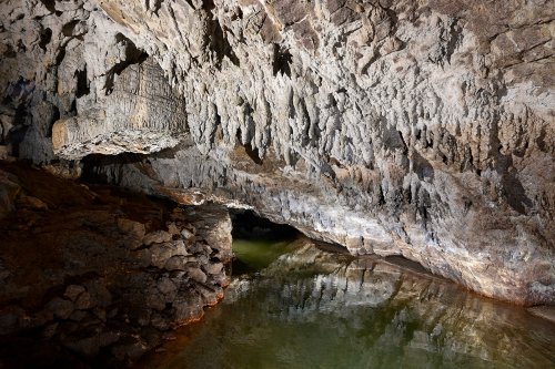 Grotte de Labouiche (Ariège) - Parois blanches concrétionnée au dessus de la rivière avec le "Pied de géant" sur la gauche(SP-23-1668)